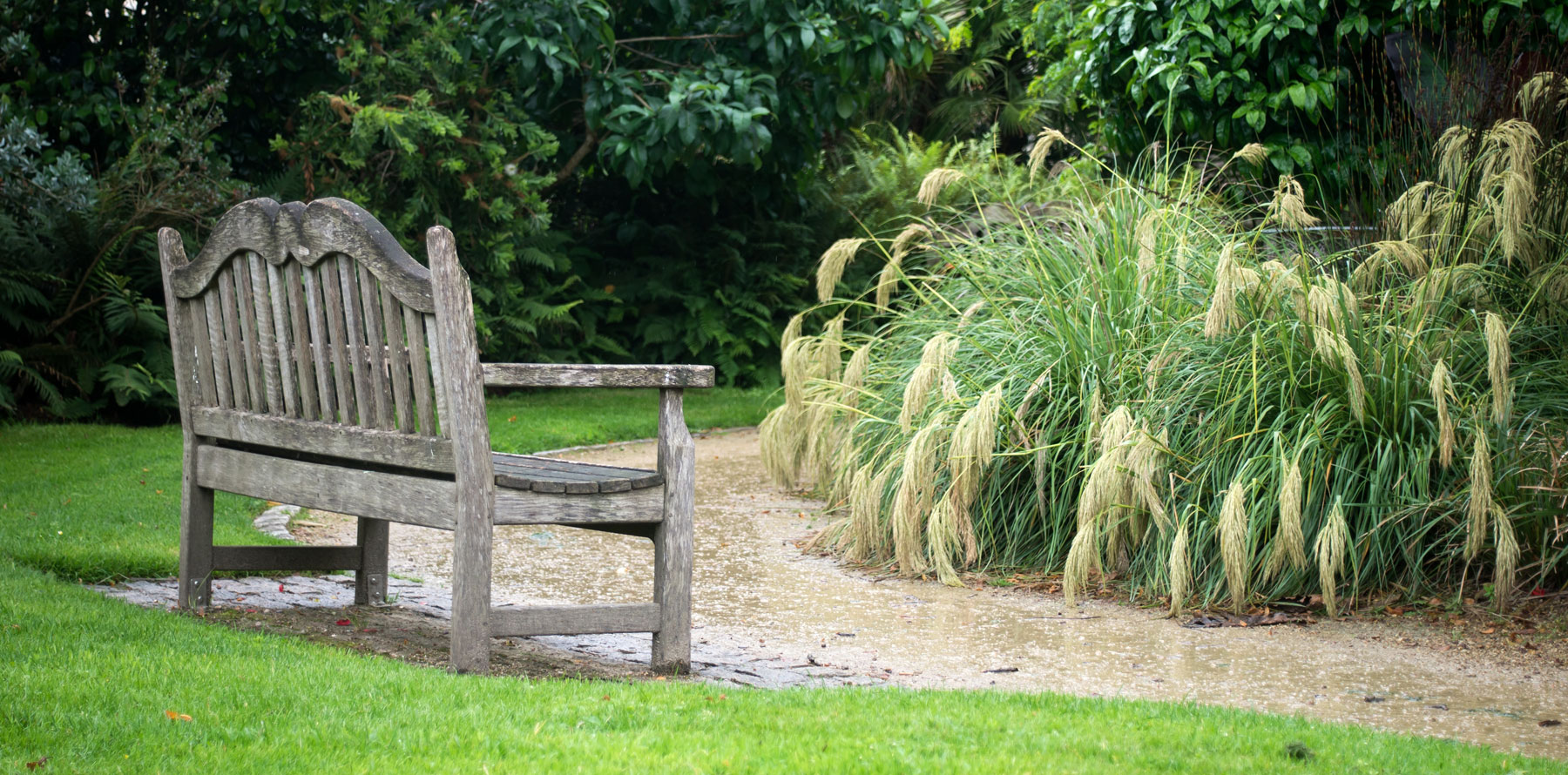 High-resolution view of a classic outdoor park bench with wooden slats.